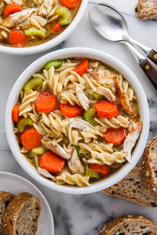 Bowl of chicken noodle soup in a white bowl.