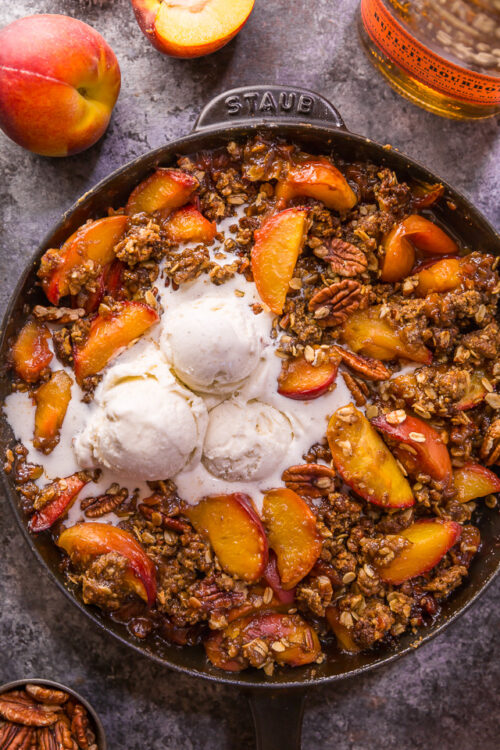 In my humble opinion, the only thing better than peach crisp is BOURBON PECAN PEACH CRISP! Made with brown sugar, fresh peaches, bourbon, and a touch of cinnamon, this is Summer in a baking dish! Serve warm while the fruit is bubbling, with a big scoop of vanilla ice cream on top! #peachcrisp #bourbonpecan #bourbonpeachpie #peaches #peachrecipes