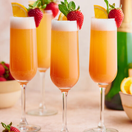 Everyone knows how to make a classic mimosa, so today I'm teaching you how to make my special sunrise strawberry mimosa recipe! Made with strawberry puree, champagne, and fresh squeezed orange juice, these are perfect for brunch! Garnish with mint sprigs, strawberries, and orange slices for an extra pretty presentation!